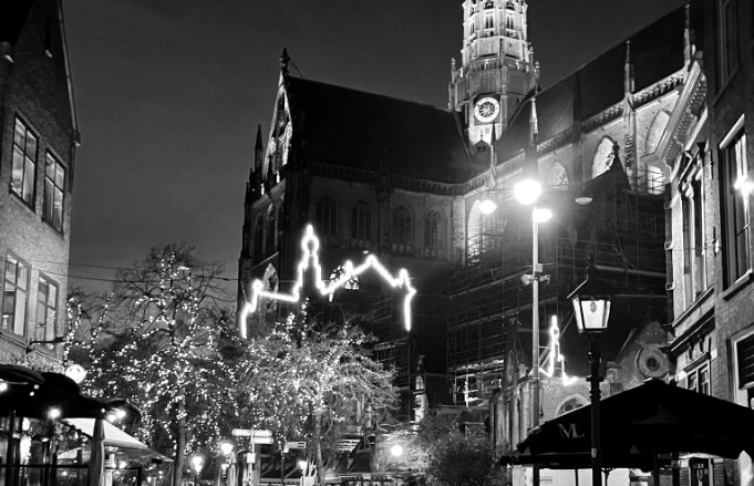 Evening in Haarlem, with the illuminated church tower and a lively street